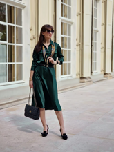 A woman wears a shirt and a triacetate skirt